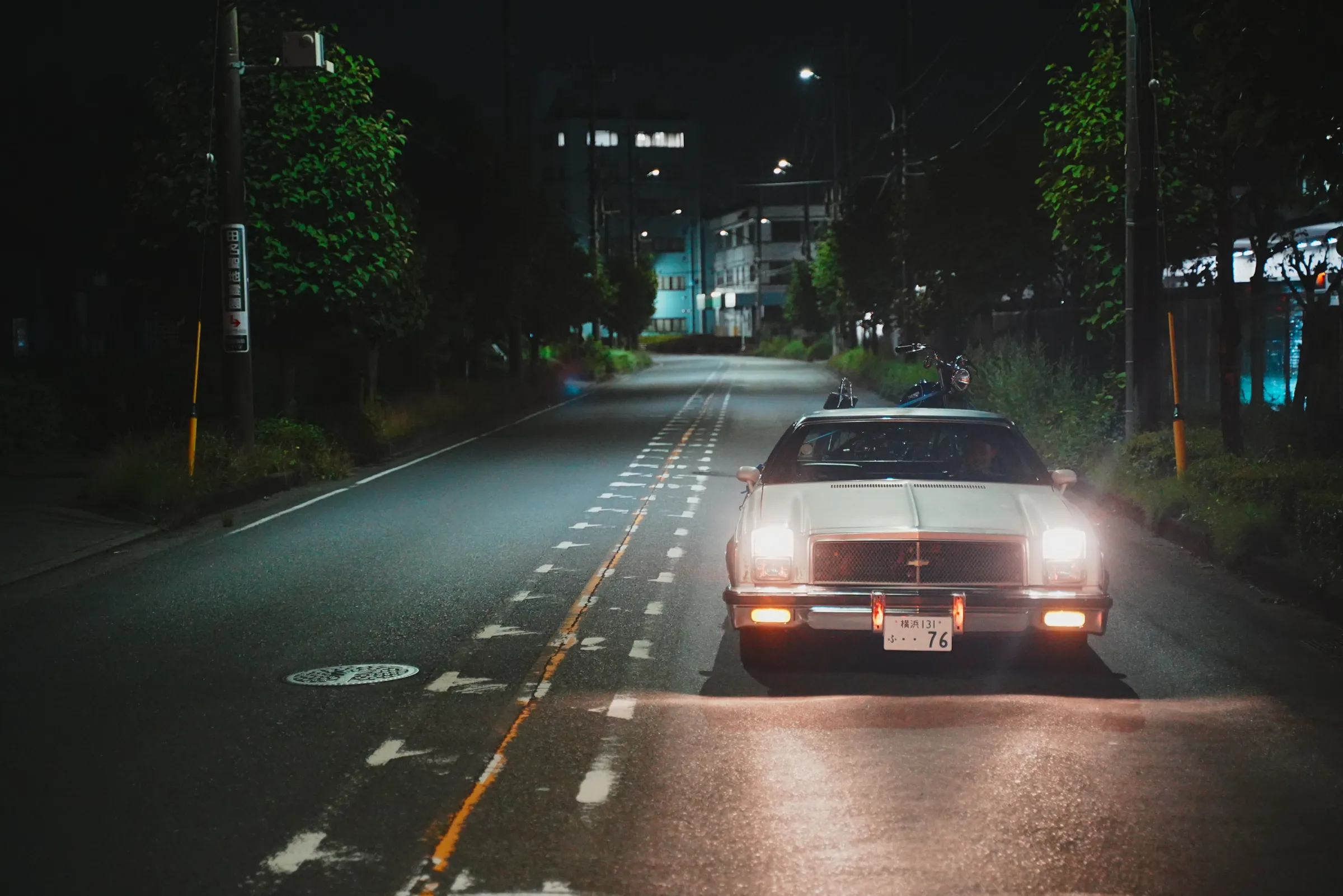 夜の住宅街を走るエルカミーノのヘッドライト